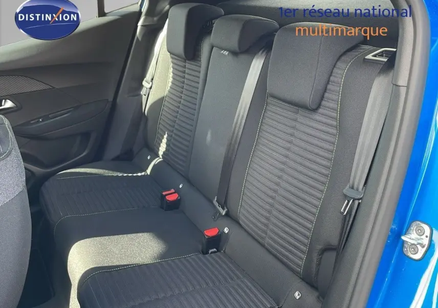 Vue intérieure sur les sièges arrière noirs avec surpiqûres vertes d'une Peugeot 2008 bleu Vertigo métal, porte ouverte côté droit.