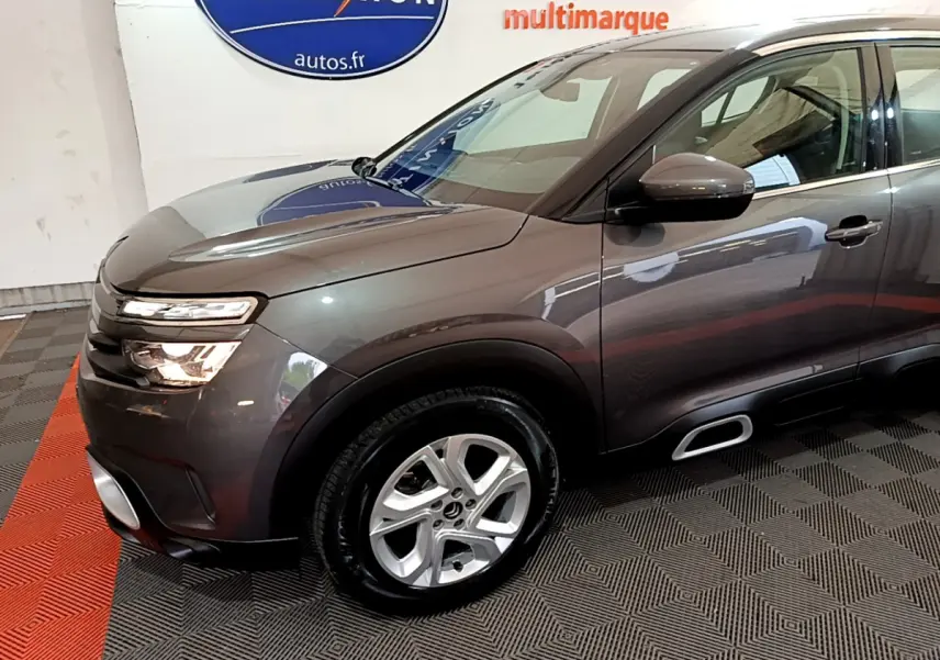 Vue 3/4 avant droit d'un Citroën C5 Aircross gris foncé avec jantes alliage et inserts Silver Anodisé sur les Airbump.