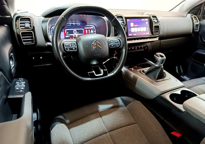 Intérieur du Citroën C5 Aircross 2020 gris foncé, vue côté conducteur avec volant cuir et tableau de bord numérique.