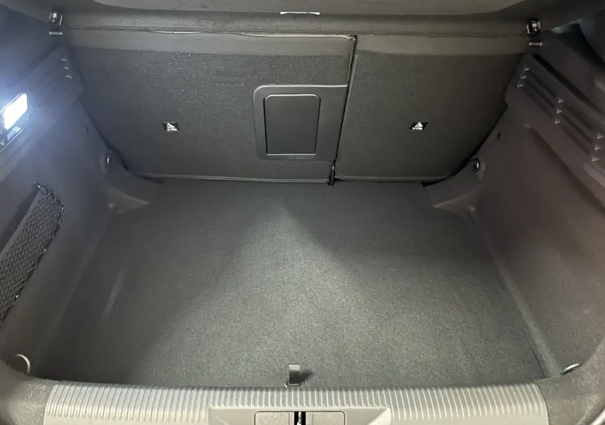 Coffre spacieux de la Peugeot 308 III Ph.2 Hybrid 145 GT vu de face, intérieur en tissu noir.