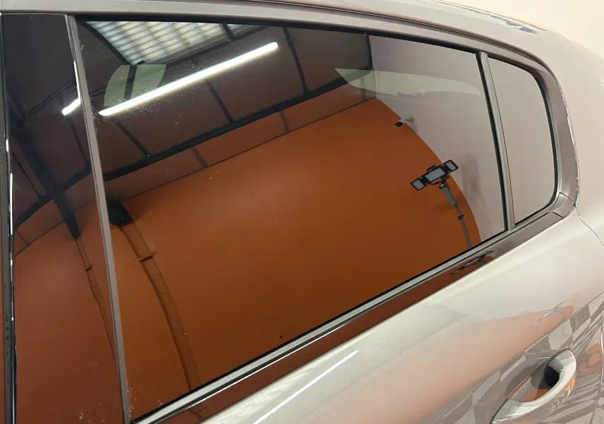 Vue rapprochée sur la porte arrière droite gris Selenium du Peugeot 308 HYBRID 145 GT avec vitrage teinté.