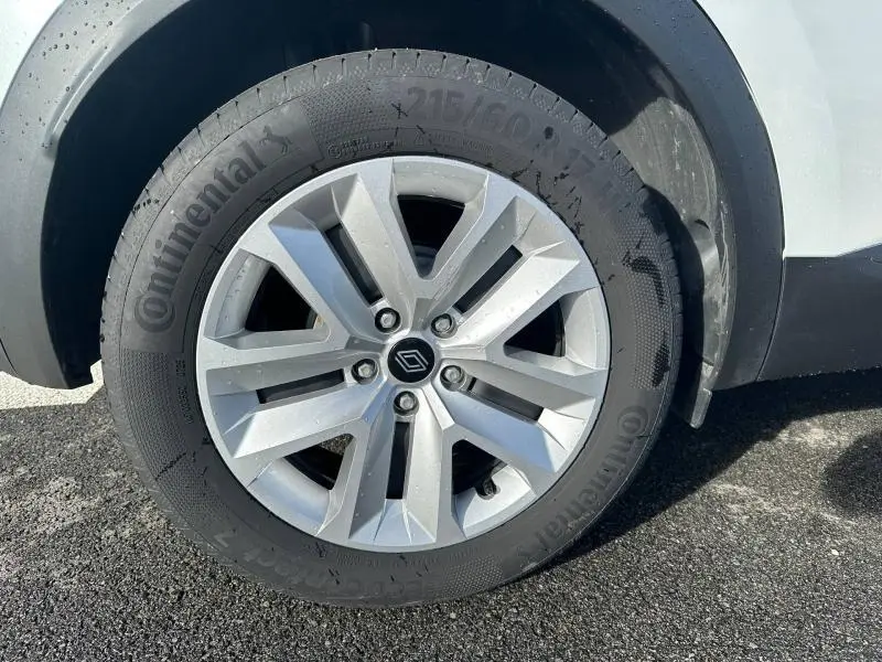 Gros plan sur la roue avant droite du Renault Captur blanc nacré avec jante alliage et pneu Continental.