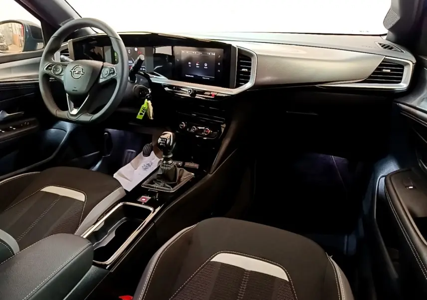 Vue intérieure avant droite de l’Opel Mokka 2024, avec tableau de bord moderne et boîte manuelle visible.