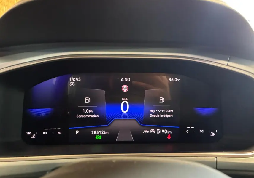 Tableau de bord numérique du Volkswagen T-Roc 2025 affichant la consommation, vitesse à 0 km/h et température extérieure à 36°C.