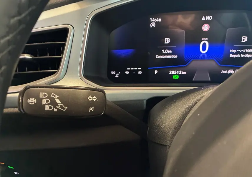 Vue rapprochée du tableau de bord numérique et du commodo gauche du Volkswagen T-Roc 2025, affichage digital clair.