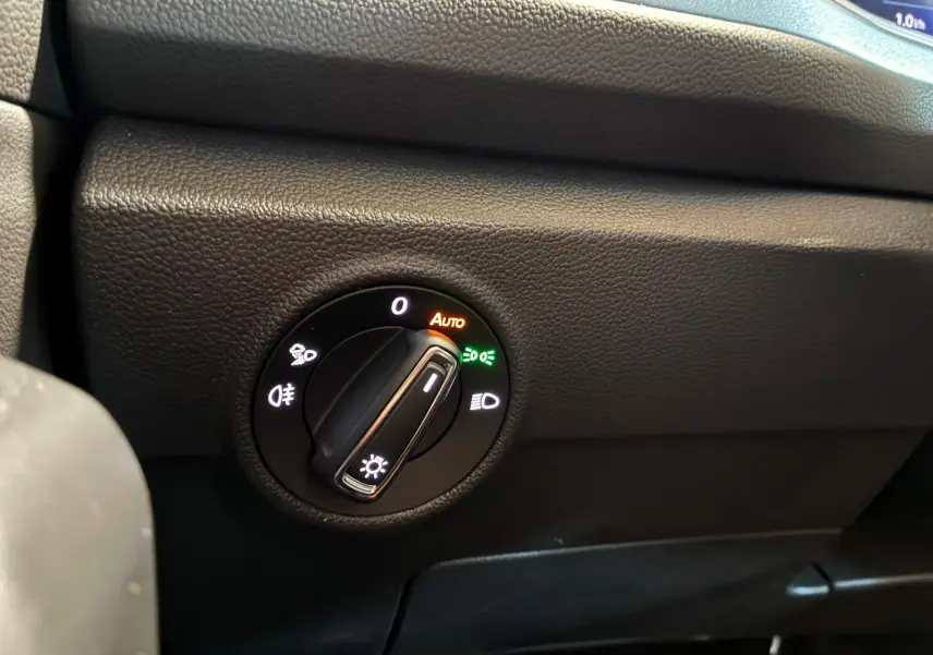 Gros plan sur le bouton de commande des phares du Volkswagen T-Roc 2025, avec réglage sur mode automatique.