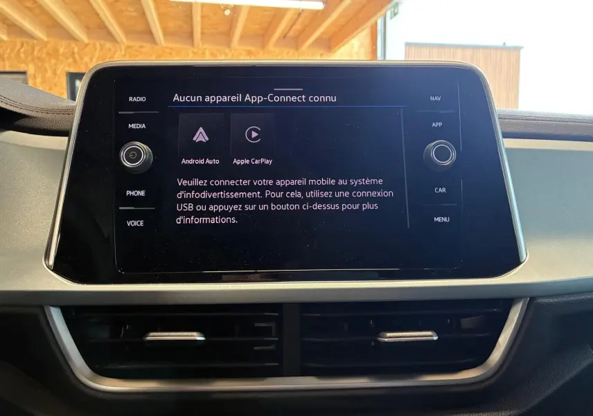 Écran tactile central du Volkswagen T-Roc 2025 affichant la connexion Android Auto et Apple CarPlay, intérieur noir.