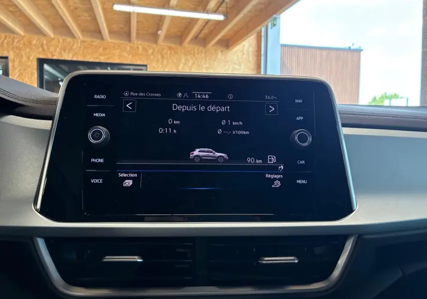 Écran central tactile du Volkswagen T-Roc 2025 affichant les données de trajet, avec tableau de bord et aérateurs visibles.