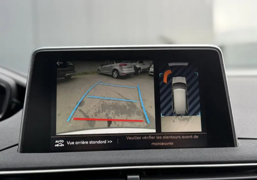 Écran tactile intérieur montrant la caméra de recul et l'affichage 360° du Peugeot 5008 bleu foncé en marche arrière.
