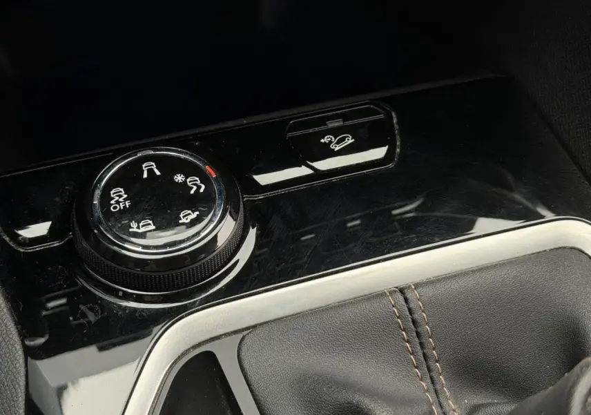 Gros plan sur la molette Advanced Grip Control et bouton Hill Assist dans l’habitacle noir du Peugeot 5008 GT Line 2019.