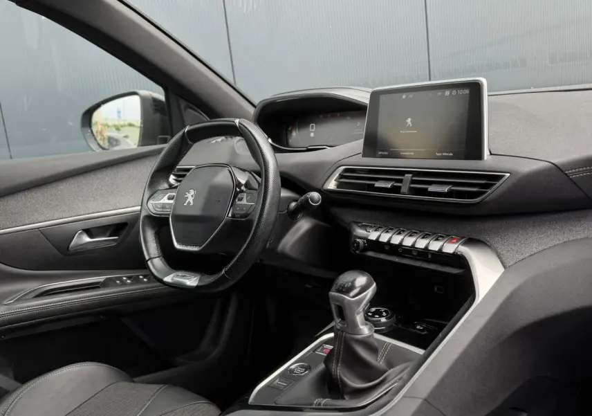 Vue intérieure côté conducteur du Peugeot 5008 bleu foncé, mettant en valeur le volant cuir GT Line et l'écran tactile central.