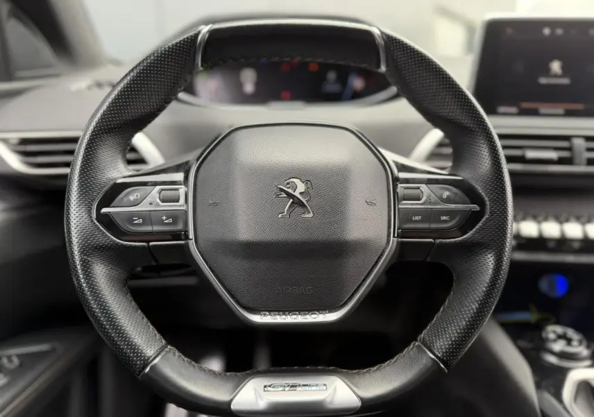 Gros plan sur le volant cuir perforé du Peugeot 5008 GT Line 2019 avec commandes intégrées et badge GT Line.