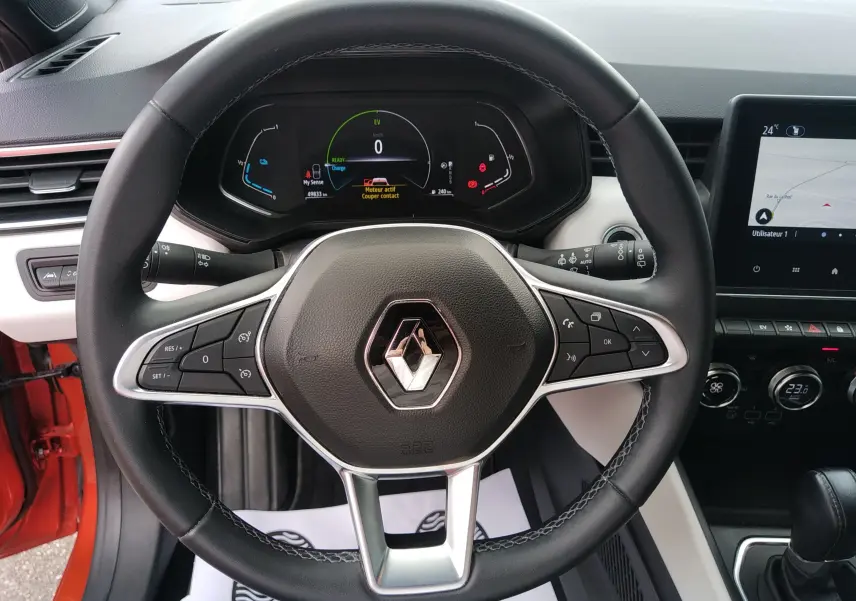 Vue rapprochée du volant noir de la Renault Clio V E-TECH 140ch 21N INTENS avec tableau de bord digital et écran central.