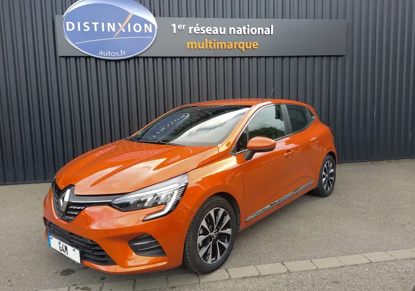 Renault Clio V E-TECH orange vue 3/4 avant droit, avec jantes alliage et feux LED distinctifs.