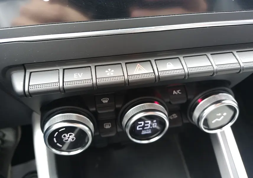 Gros plan sur la console centrale de la Renault Clio V E-TECH 140ch 21N Intens, montrant les commandes de climatisation digitales.