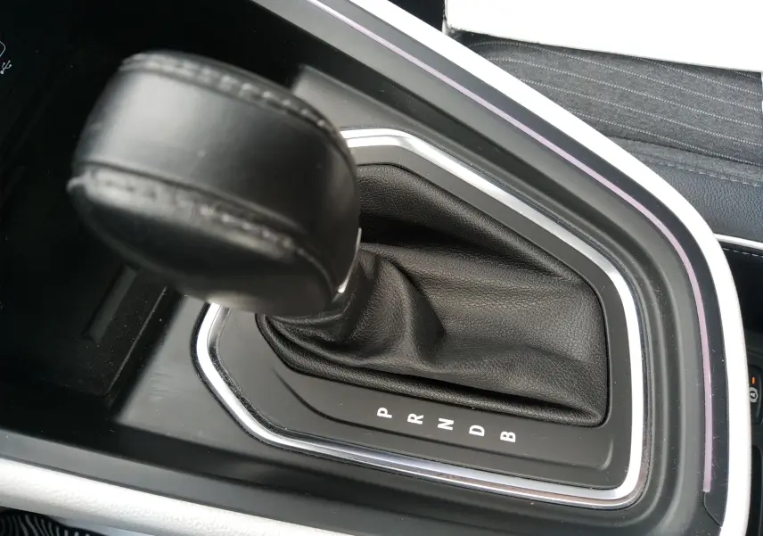 Gros plan sur le levier de vitesses automatique noir de la Renault Clio V E-TECH 140ch 21N INTENS, entouré de finitions chromées.