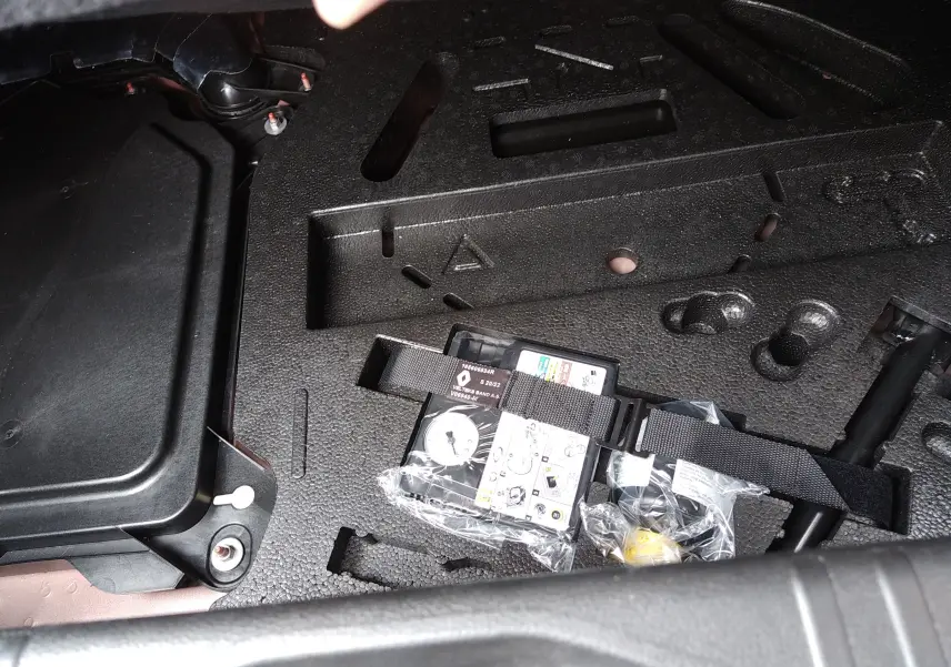 Détail du coffre de la Renault Clio V E-TECH 140ch 21N Intens 2022, montrant le kit de réparation de pneus rangé dans le compartiment.