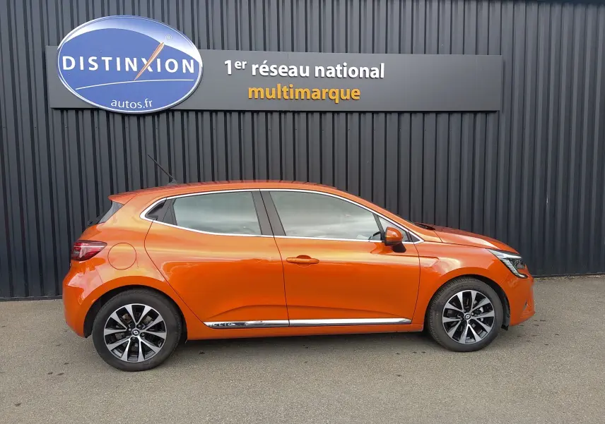 Profil droit d'une Renault Clio V E-TECH hybride orange 2022 avec jantes alliage et poignées de porte couleur carrosserie.