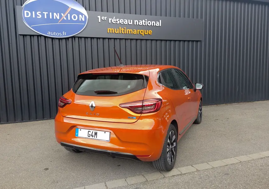 Vue 3/4 arrière droite d'une Renault Clio V E-TECH orange 2022 avec feux LED et jantes alliage noires.
