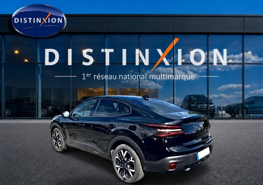 Vue 3/4 arrière droite d'une Citroën C4 X noire 2025, avec feux arrière LED et jantes alliage distinctives.