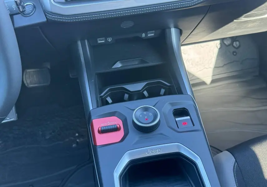 Vue rapprochée de la console centrale du Jeep Compass Yosemite 2026, avec molette de boîte auto et bouton rouge Selec-Terrain.