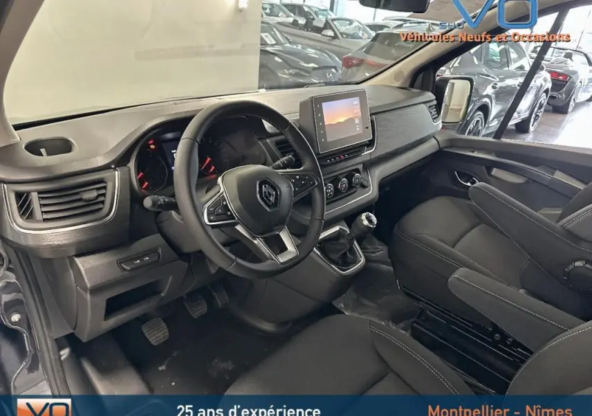 Intérieur du Renault Trafic Fourgon gris 2025, vue côté conducteur sur tableau de bord et volant multifonction.