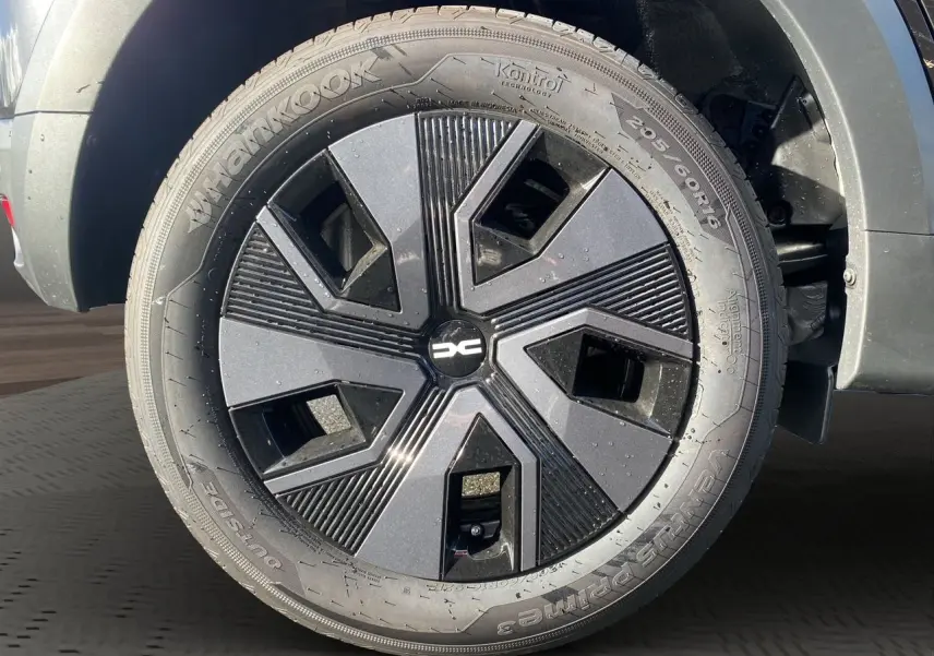 Gros plan sur la roue avant droite noire de la Dacia Sandero Stepway 2025 avec jante au design géométrique moderne.