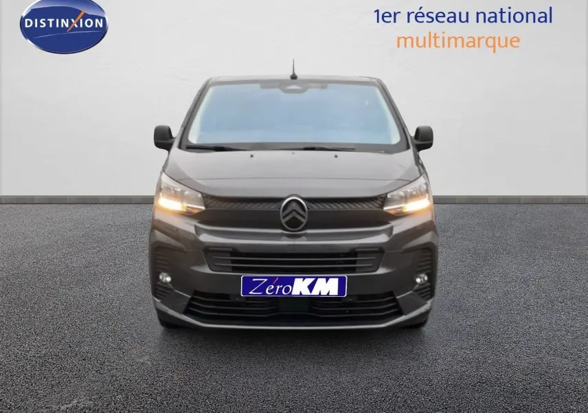 Vue frontale du Citroën Jumpy cabine approfondie gris titane métal avec feux allumés sur fond neutre.