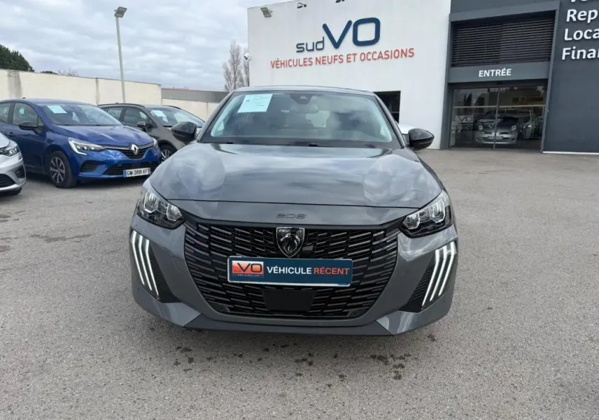 Vue avant d’une Peugeot 208 Hybrid 145 gris avec calandre noire et feux diurnes à LED en griffes distinctives.