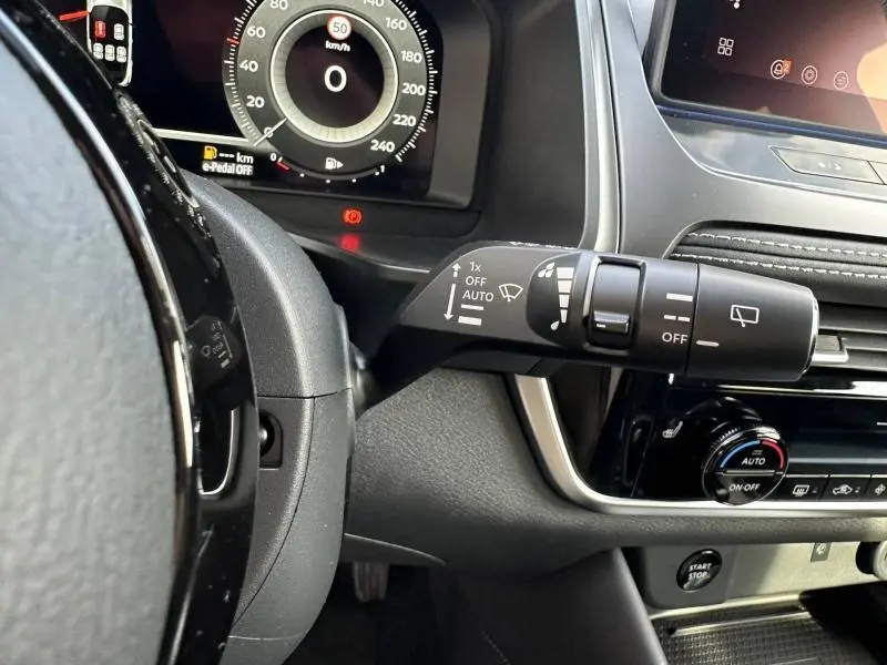 Détail intérieur côté gauche du Nissan Qashqai Hybrid e-POWER 2025, montrant la commande des essuie-glaces et le tableau de bord numérique.