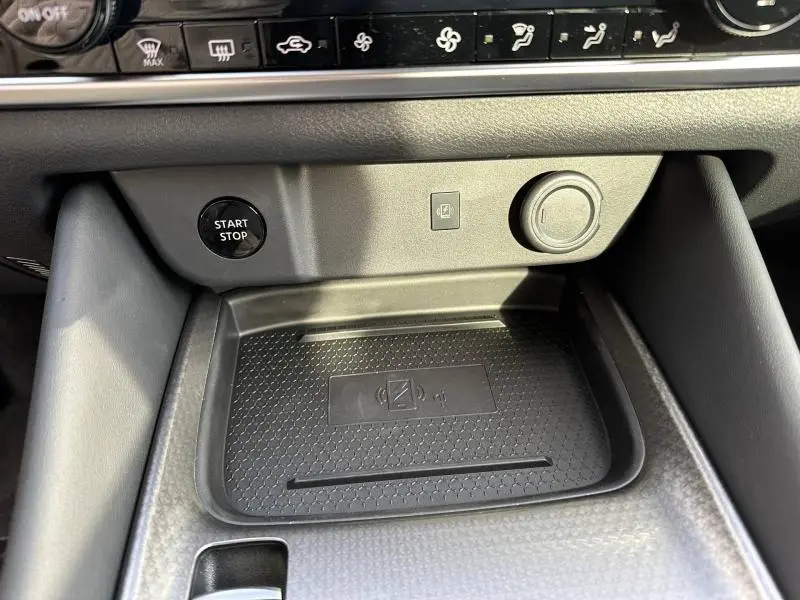 Gros plan sur la console centrale du Nissan Qashqai Hybrid e-POWER 2025, montrant le bouton Start/Stop et le chargeur sans fil noir.