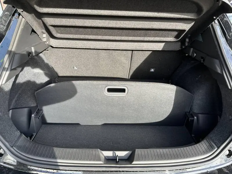 Coffre ouvert vu de dessus du Nissan Qashqai Hybrid e-POWER 2025 noir Kuro Métallisé, montrant l'espace de rangement et la cloison amovible.