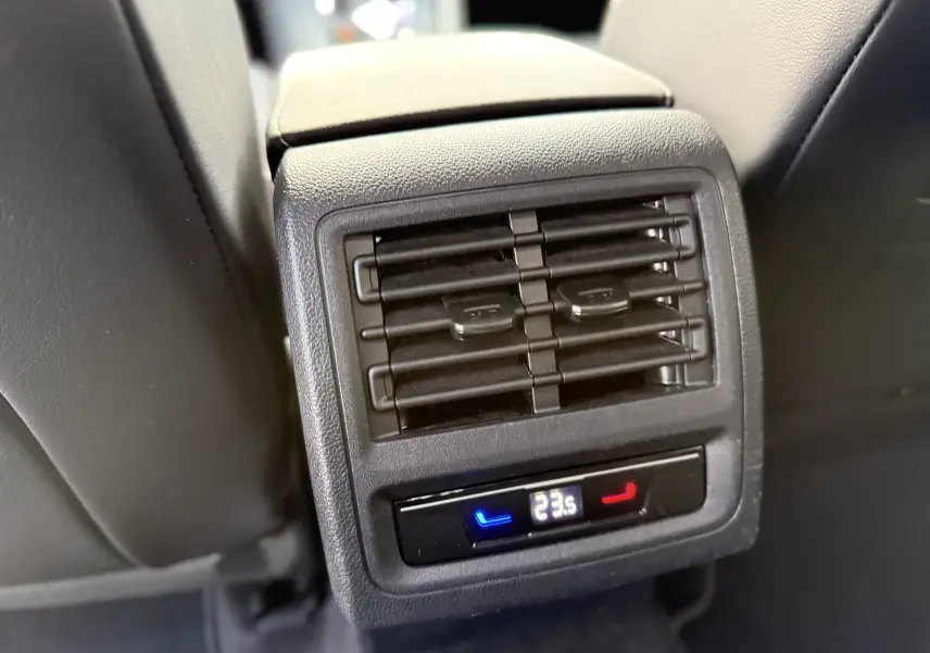 Détail de la sortie d’air arrière avec réglage de la climatisation affichant 23,5°C dans une Volkswagen Golf SW gris lunaire.