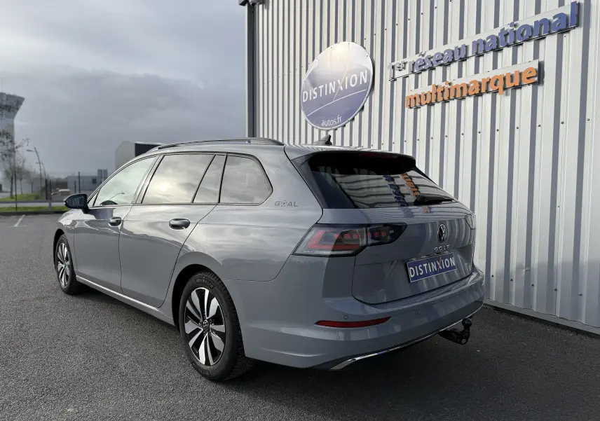 Vue 3/4 arrière droite d'une Volkswagen Golf SW gris lunaire 2025 avec attelage et jantes alliage.