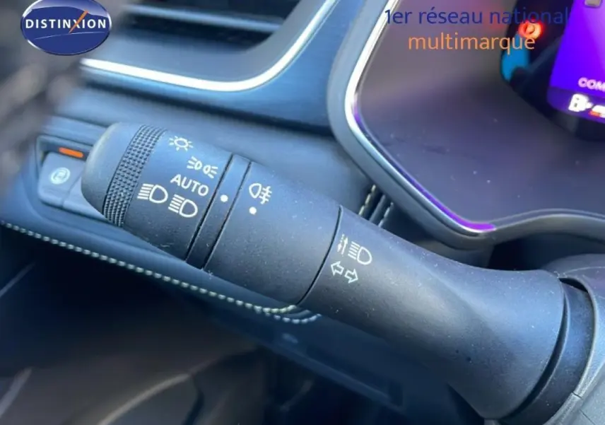 Gros plan sur la commande des phares et clignotants du Renault Symbioz 2025, intérieur noir avec coutures blanches.