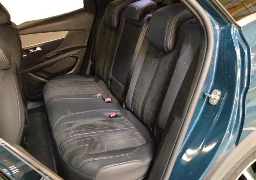 Vue intérieure côté droit montrant la banquette arrière en cuir noir du Peugeot 3008 Hybrid 225 e-EAT8 GT Pack bleu clair.
