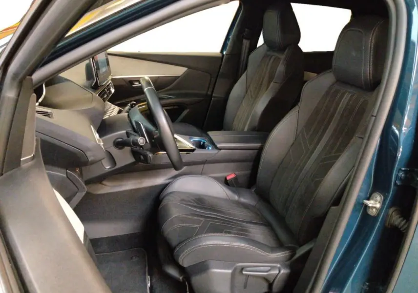 Vue intérieure côté conducteur du Peugeot 3008 Hybrid 225 e-EAT8 GT Pack bleu clair, montrant les sièges en cuir et le tableau de bord moderne.