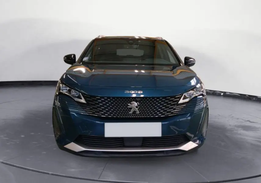 Vue frontale d'un Peugeot 3008 Hybrid 225 e-EAT8 GT Pack bleu foncé avec calandre distinctive et phares LED anguleux.