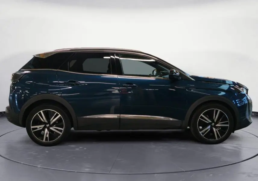 Vue de profil droit du Peugeot 3008 Hybrid 225 e-EAT8 GT Pack bleu foncé avec jantes alliage noires et toit noir.