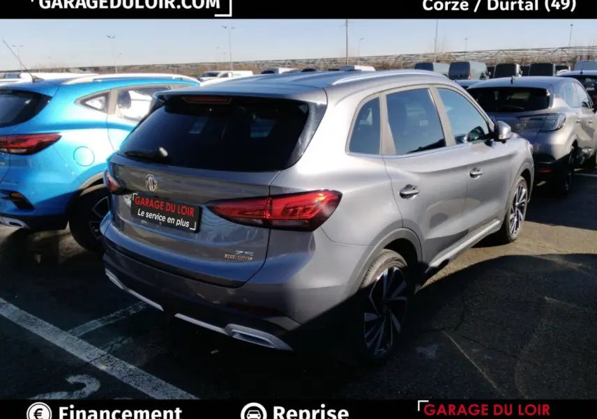 Vue 3/4 arrière droite d'un MG ZS gris clair hybride avec feux arrière LED et jantes alliage noires.