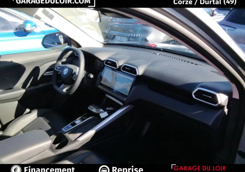 Intérieur du MG ZS Hybrid+ Luxury 2025, vue côté conducteur, tableau de bord noir avec écran tactile central.