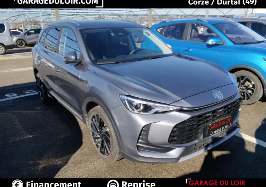 MG ZS 1.5L Hybrid+ Luxury gris clair, vue 3/4 avant, calandre noire et jantes foncées distinctives.
