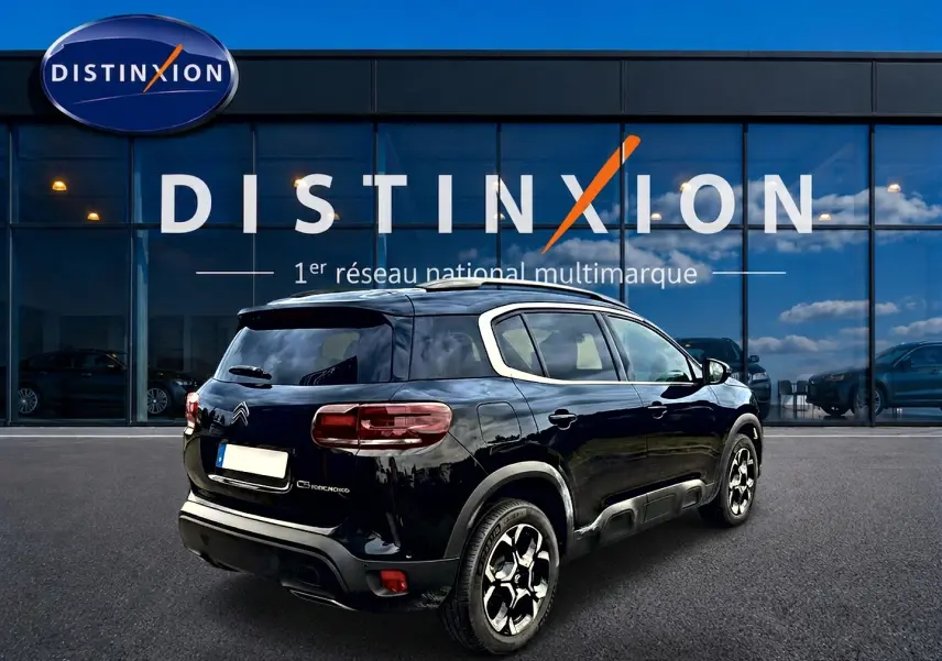 Citroën C5 Aircross noir vue 3/4 arrière droit, avec jantes alu et vitres arrière teintées devant showroom Distinxion.