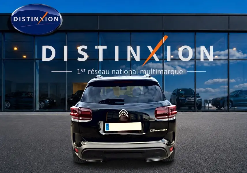 Vue arrière d'un Citroën C5 Aircross noir 2025, avec feux LED et barres de toit visibles devant une vitrine Distinxion.
