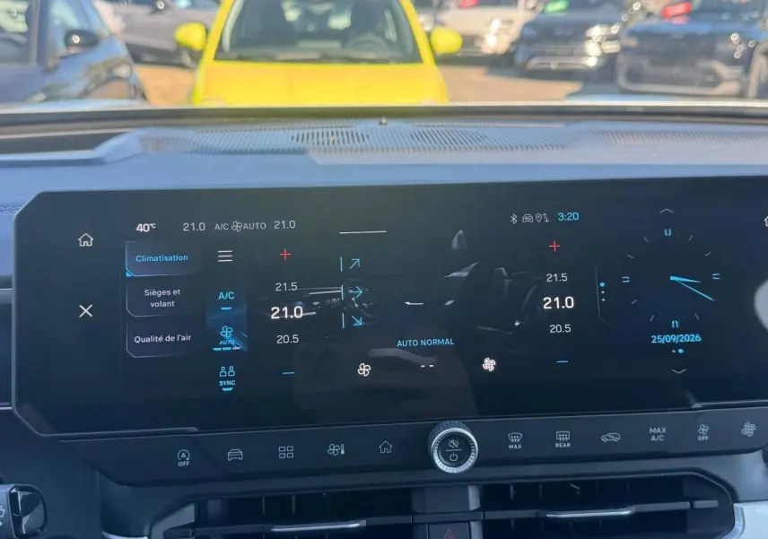 Vue rapprochée de l'écran tactile multifonction du tableau de bord du Jeep Compass 2026 avec commandes climatisation et horloge digitale.