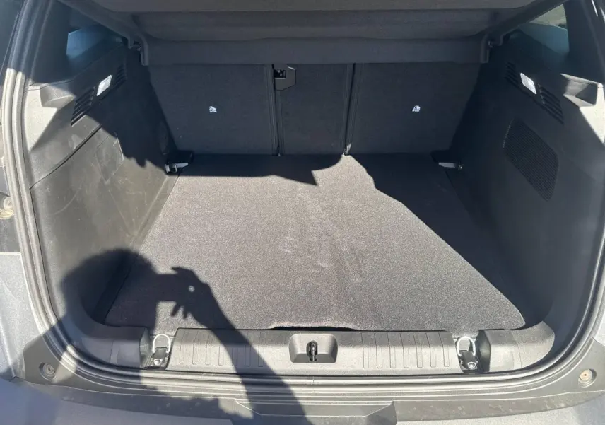 Coffre ouvert vu de l'arrière d'un Jeep Compass 2026 Yosemite avec toit noir, espace de chargement vide et tapis noir.