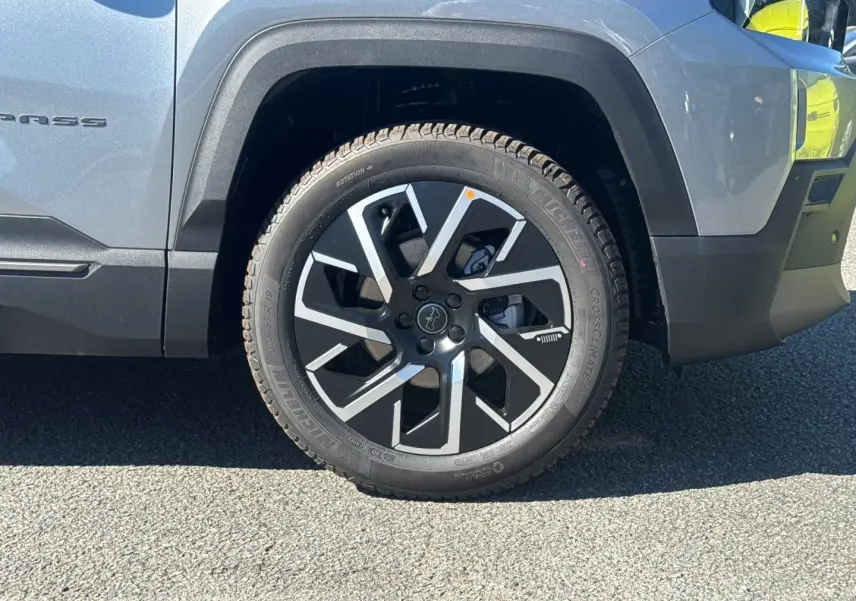 Gros plan sur la roue avant droite du Jeep Compass Yosemite gris avec jante alu noire et argentée.