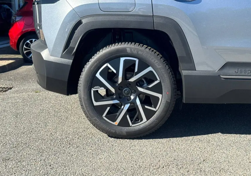 Gros plan sur la roue arrière droite du Jeep Compass Yosemite gris avec jante alu noire et argentée.