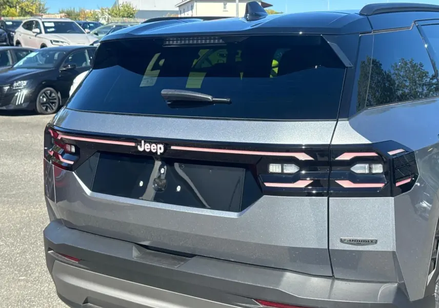 Vue arrière droite du Jeep Compass 2026 Yosemite avec toit noir, feux arrière LED et badge Summit visible.