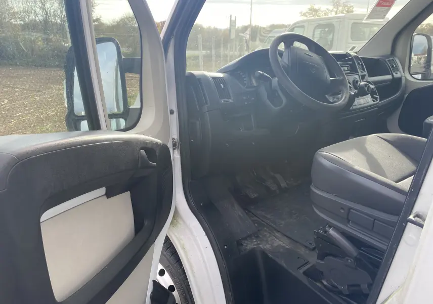 Vue intérieure côté conducteur du Citroën Jumper blanc 2011, montrant le tableau de bord et les sièges avant.